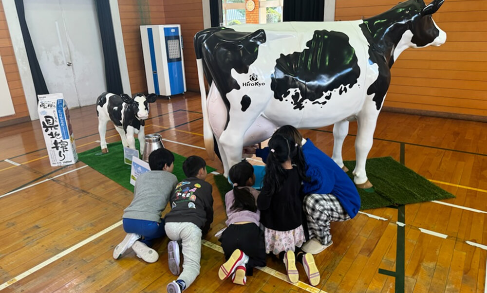乳搾り体験をしている子供達