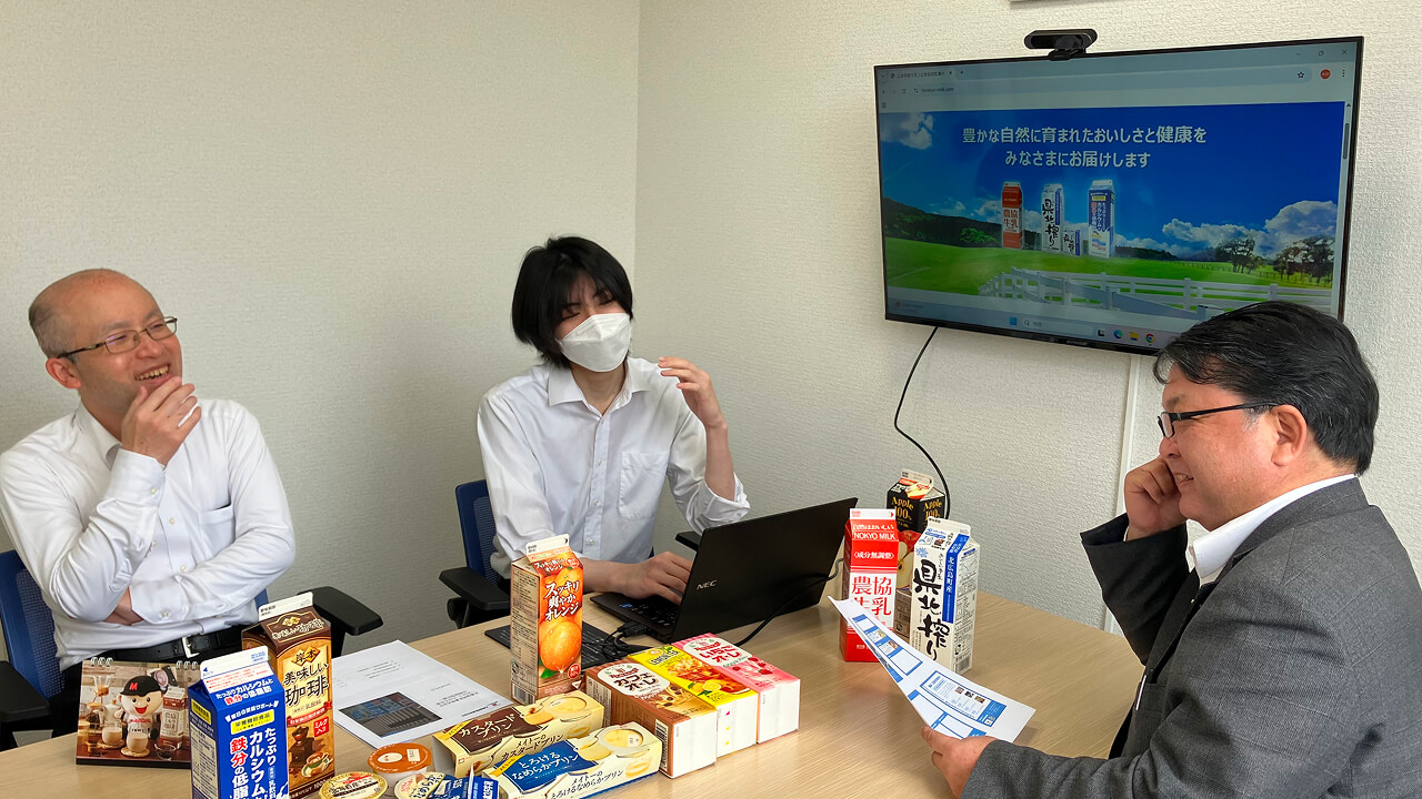 事務所で社員がにぎやかな会話をしている様子